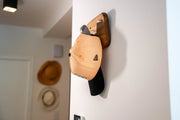 Le porte manteau et clees teevasion accroche au mur portant une casquette 