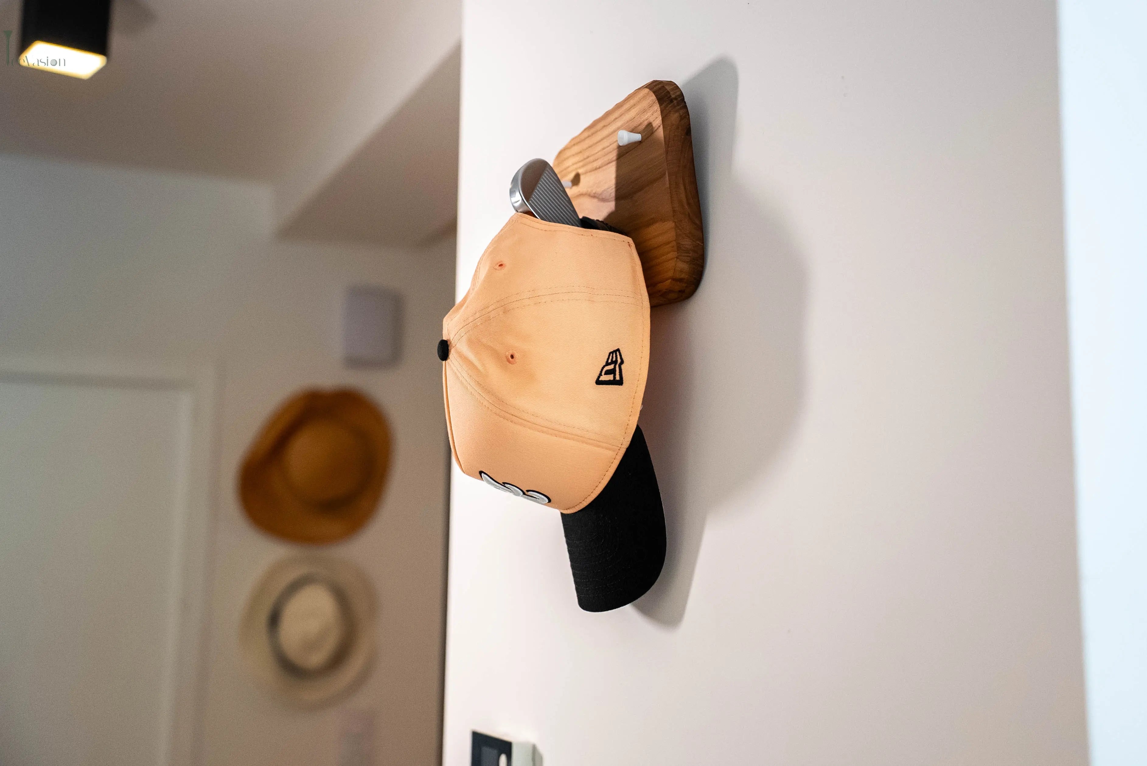 Le porte manteau et clees teevasion accroche au mur portant une casquette 
