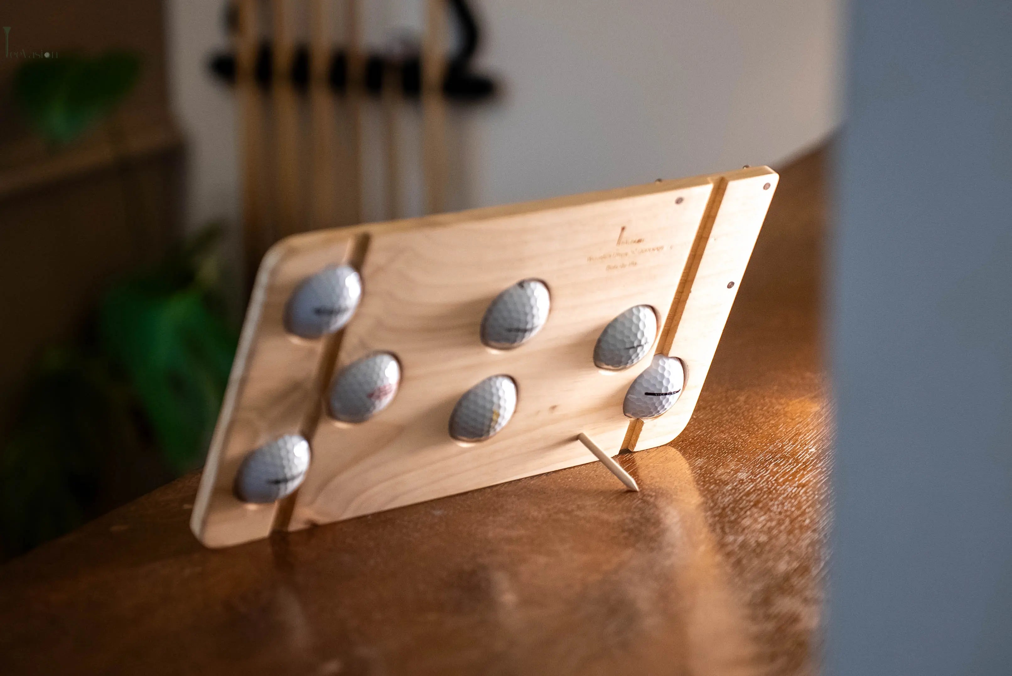 Un support 7 balles sur caisse de vin numerote vue de derriere pose sur un meuble en bois avec son tee 