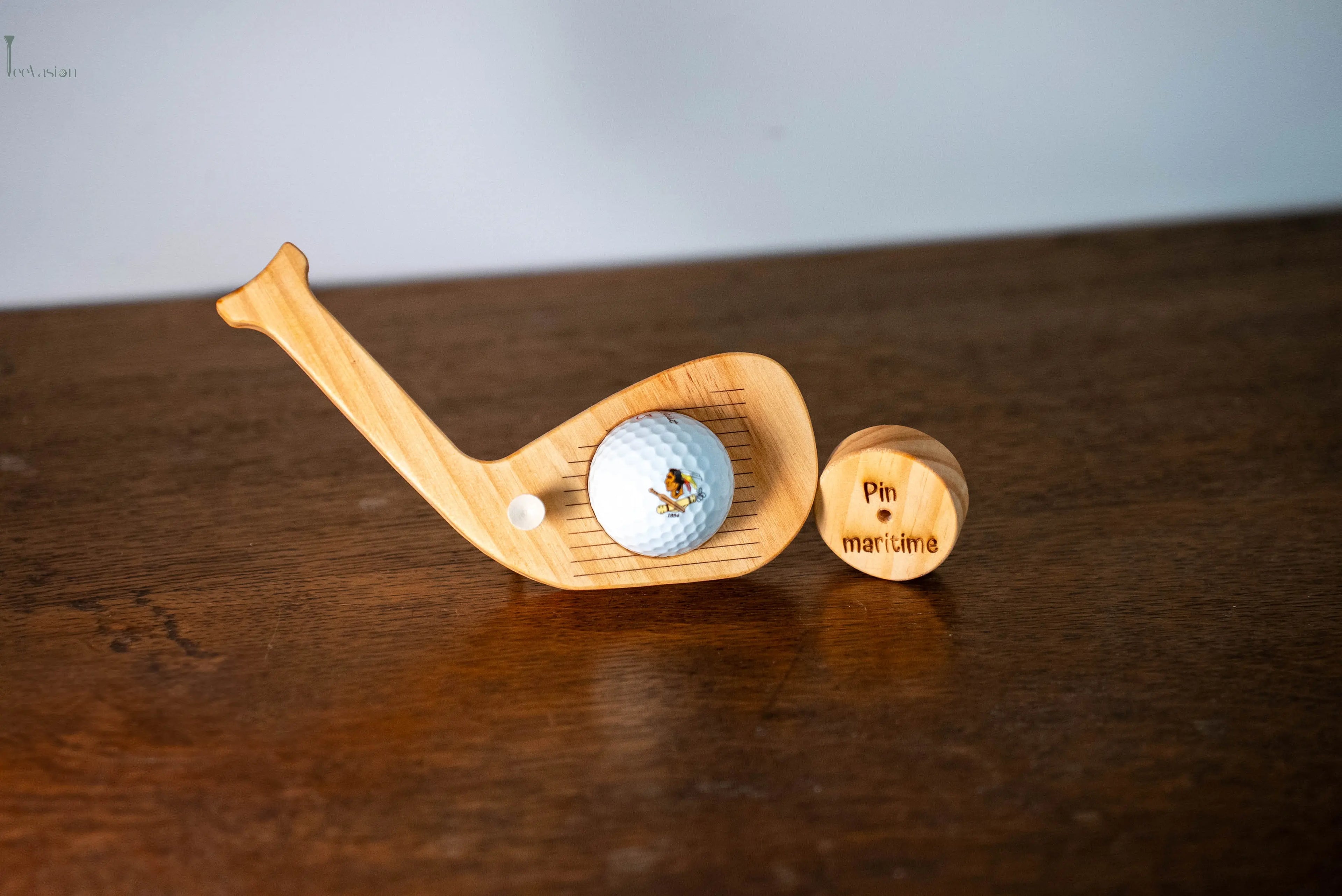 trophée en forme de tête de club en bois pin maritime posé grâce a son tee sur un meuble