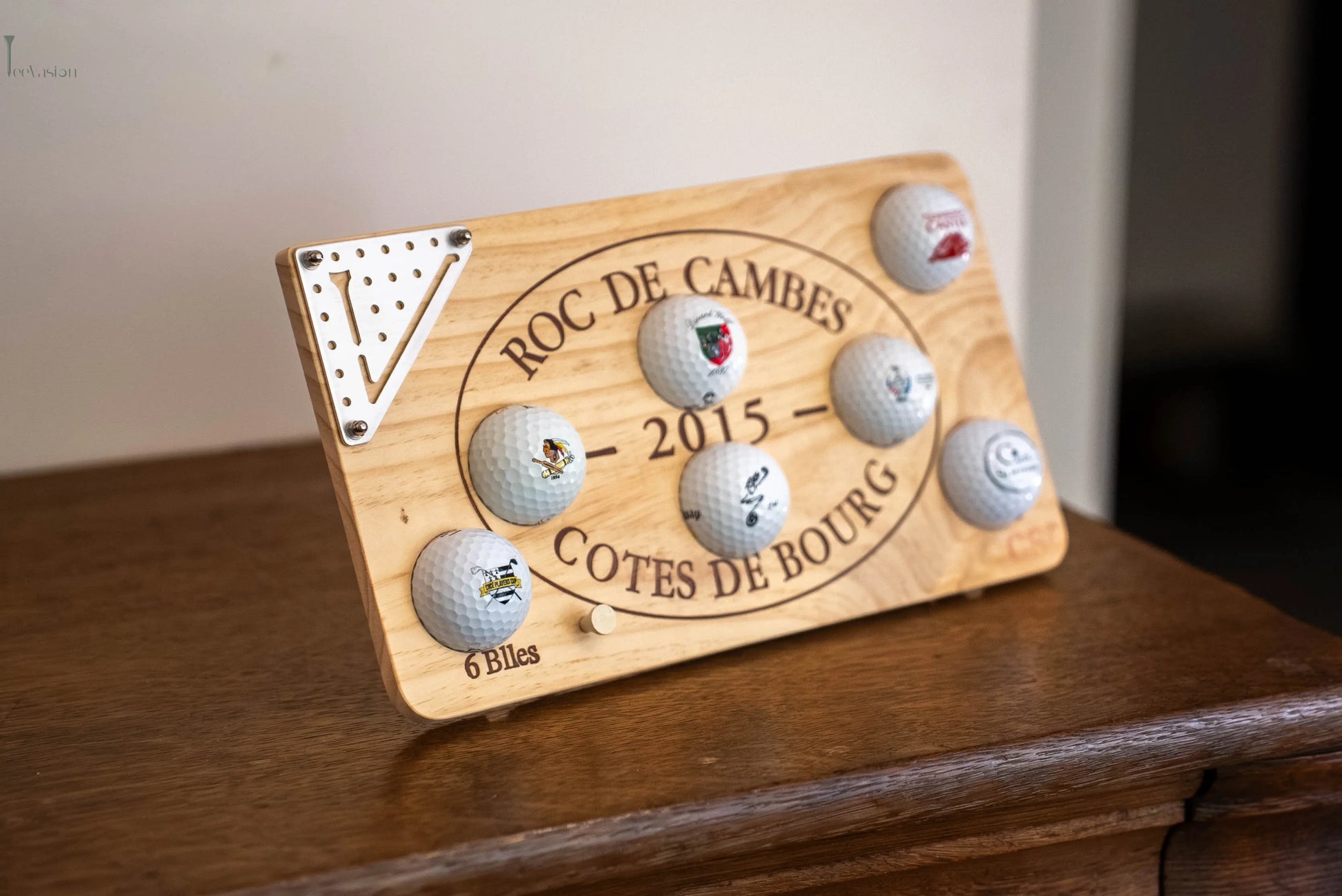 Un support 7 balles sur caisse de vin avec un plaque teevasion classique pose avec son tee sur un meuble en bois