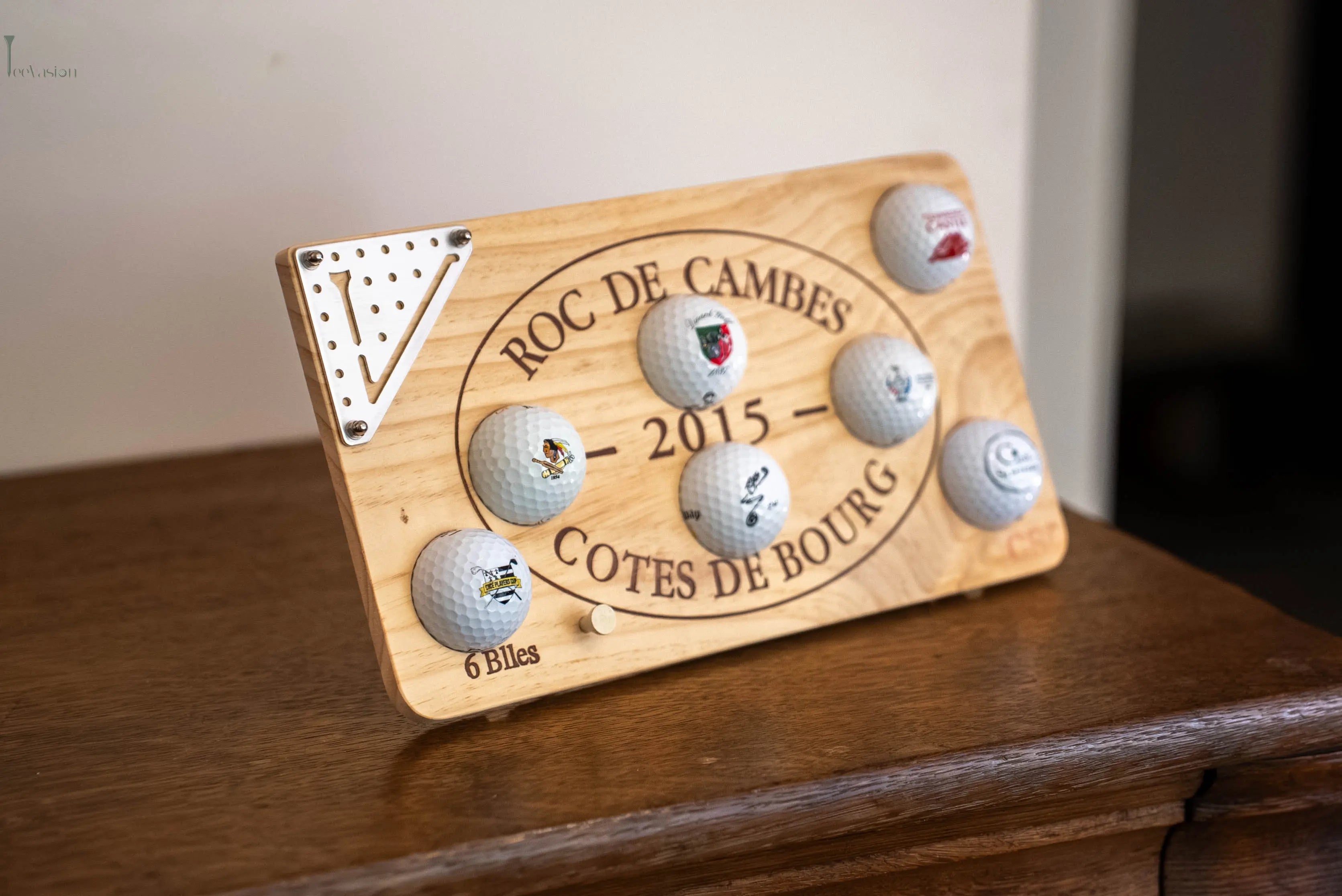 Un support 7 balles sur caisse de vin avec un plaque teevasion classique pose avec son tee sur un meuble en bois