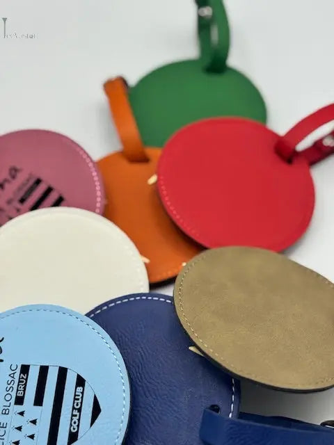 Des tags de sac colorés et gravés posés sur un fond blanc 